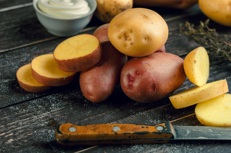 Fresh potatoes on the wood background