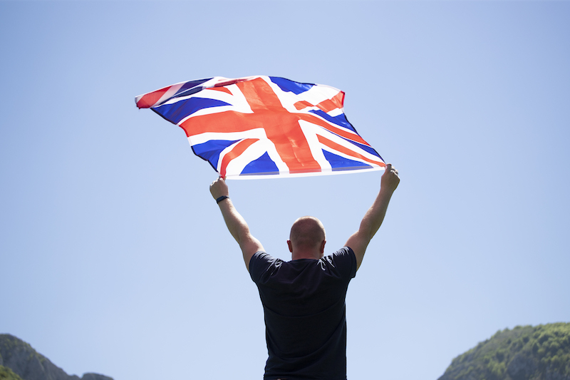 Man holding flag of UK. Patriot and supporter of Great Britain.