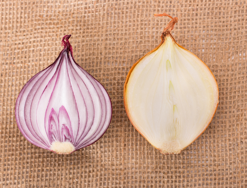 Red onion cut, isolated on sackcloth brown tissue background