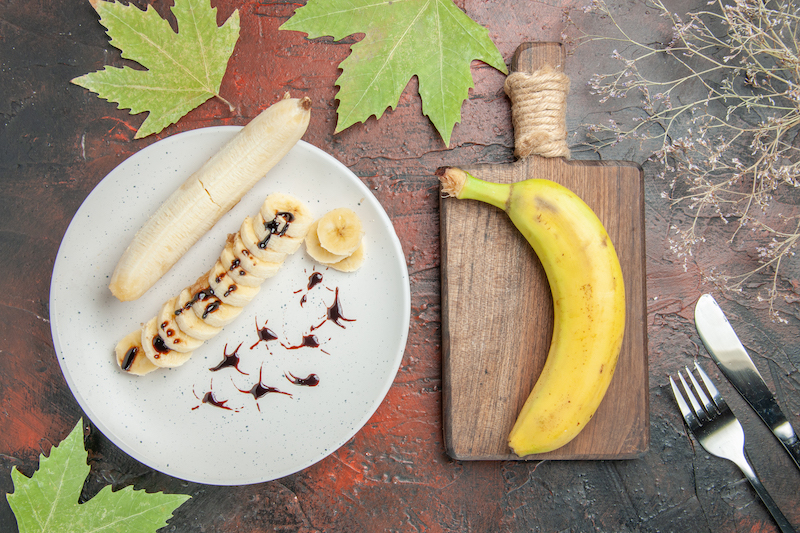 top view delicious banana with sliced pieces inside plate on a dark background tree photo fruit sweet