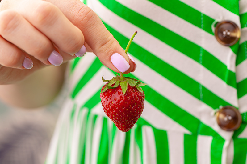 Beautiful large red strawberry in a hand. Close up.