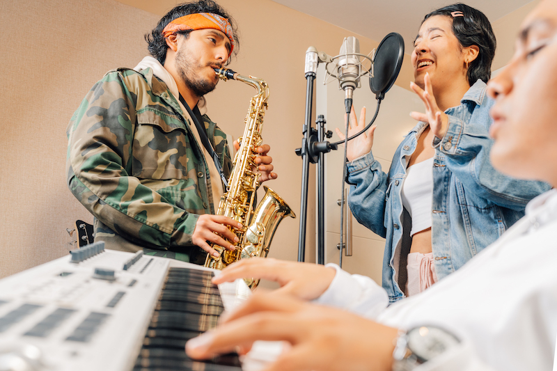 Joyful musicians recording a new album in a home record studio