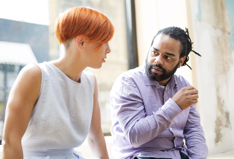 Redhaired young woman and black guy talking