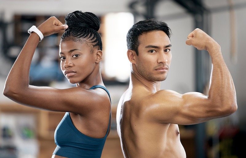 Portrait, black woman or personal trainer flexing muscles or body goals in training, workout or exe.