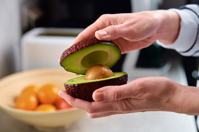 Woman hold fresh ripe avocado