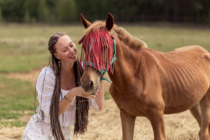 girl in a field with a horse