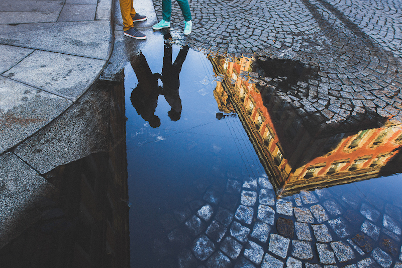 Silhouette hugging guy and girl in reflection in puddle on a street. Saint-Petersburg Love