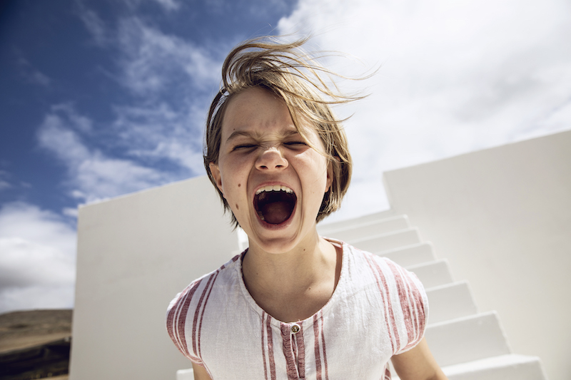 Girl with windswept hair, screaming out loud