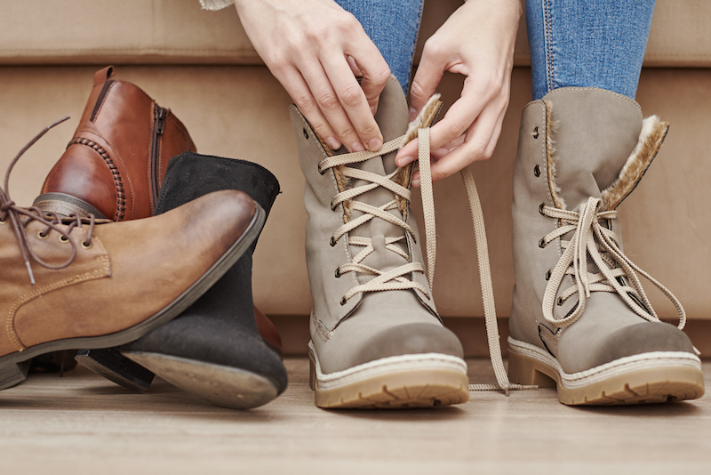 Woman chooses comfortable shoes among bunch of different pairs