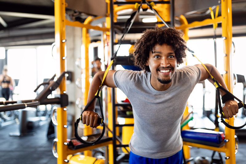 Man doing push ups training with trx fitness straps in the gym. Workout healthy lifestyle sport concept