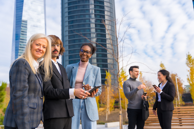 Multi-ethnic business colleagues or executives, looking at technologies and talking about work