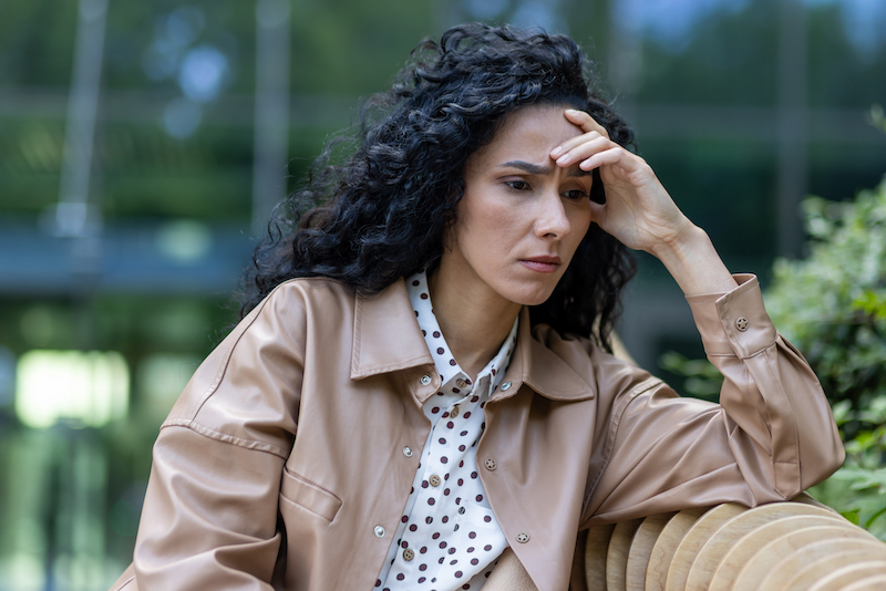 Depressed mature adult woman sitting on bench outside office building, businesswoman boss upset and disappointed with results of achievement at work, bankruptcy and financial loss economic crisis.