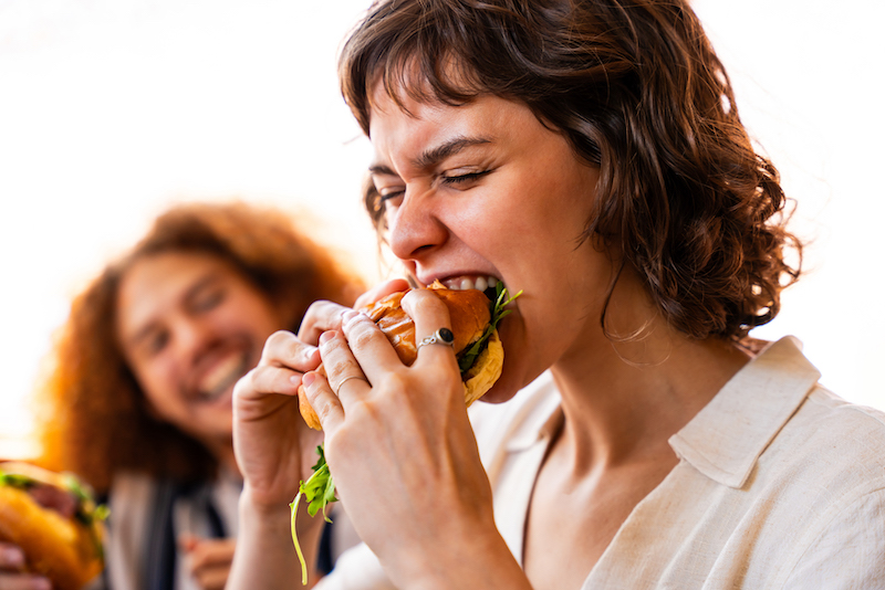 lady biting into a hamburger