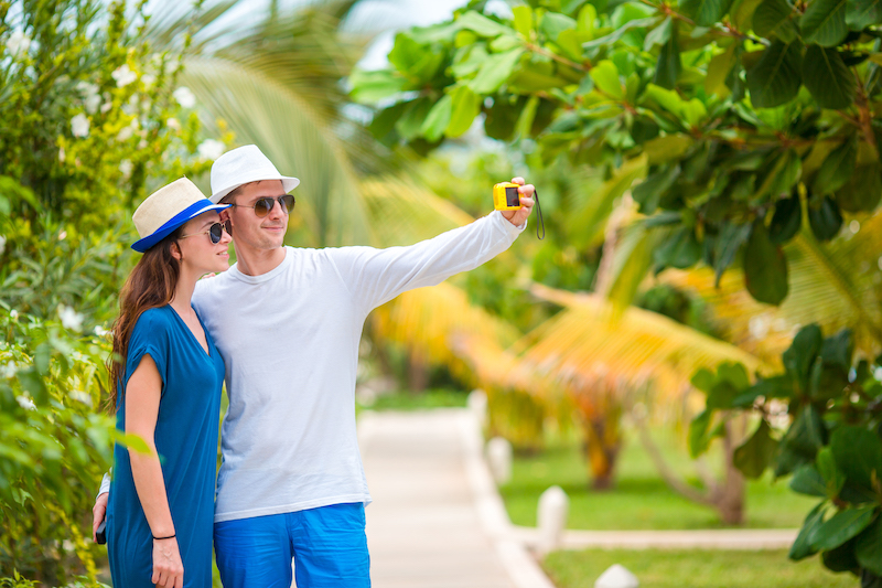 Young happy couple making a selfie with mobile phone on tropical vacation