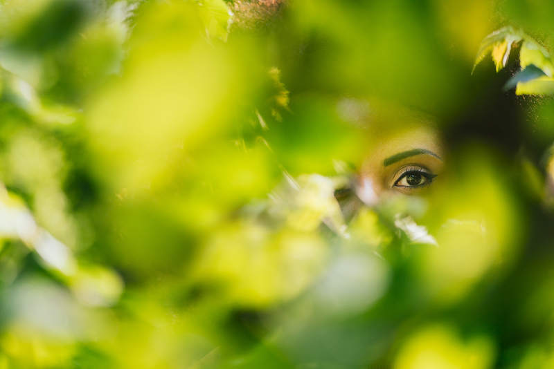 Nice portrait of beautiful afro woman through the leaves