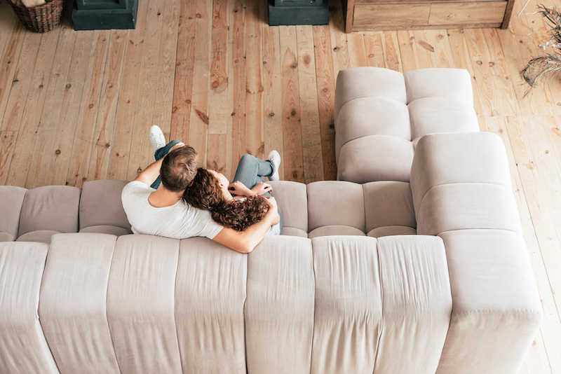 overhead view of couple embracing on sofa in living room