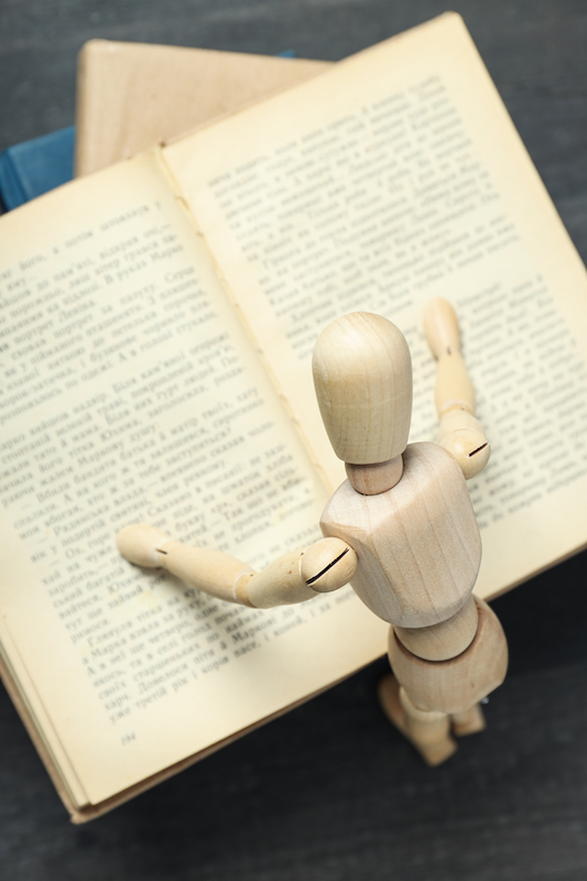 figurine reading a dictionary